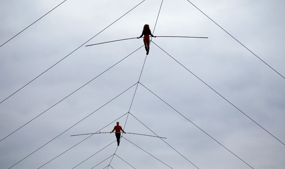 Nik Wallenda and his sister Lijana Wallenda perform on a tightrope before the NASCAR Sprint Cup Series auto race at Charlotte Motor Speedway in Concord, N.C., Saturday, Oct. 12, 2013. (AP Photo/Terry Renna)