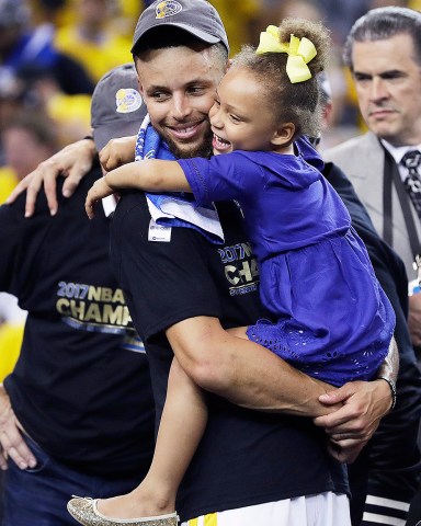 Golden State Warriors guard Stephen Curry hugs his daughter Riley after Game 5 of basketball's NBA Finals between the Warriors and the Cleveland Cavaliers in Oakland, Calif., Monday, June 12, 2017. The Warriors won 129-120 to win the NBA championship. (AP Photo/Marcio Jose Sanchez)