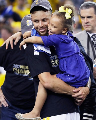 Golden State Warriors guard Stephen Curry hugs his daughter Riley after Game 5 of basketball's NBA Finals between the Warriors and the Cleveland Cavaliers in Oakland, Calif., Monday, June 12, 2017. The Warriors won 129-120 to win the NBA championship. (AP Photo/Marcio Jose Sanchez)