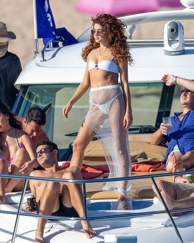 *EXCLUSIVE* Cabo San Lucas, MEXICO - Sarah Hyland looked incredible in a sexy white bikini with a perilously high-rise front which left nothing to the imagination as she parties on a boat with fiancé Wells Adams and a few friends. The 28 year old ModernFamily alum was seen enjoying a colorful drink while dancing and partying with her pals. Sarah broke up the dancing session with some yoga poses on a surf board and at one point looked utterly delighted when she stood on the board for a Warrior II. Sarah’s tiny cheeky bikini showed off her svelte figure and the dinosaur tattoo she has on her butt. The actress shared details of a visit to a dr last year in which she tried to have the ink removed with a laser. It appears she may have abandoned the effort to have the tattoo removed after the first, painful experience last summer.Pictured: Sarah Highland and Wells AdamsBACKGRID USA 3 DECEMBER 2020 BYLINE MUST READ: HEM / BACKGRIDUSA: +1 310 798 9111 / usasales@backgrid.comUK: +44 208 344 2007 / uksales@backgrid.com*UK Clients - Pictures Containing ChildrenPlease Pixelate Face Prior To Publication*