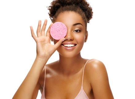 Funny girl holding pink sponge near her face. Portrait of young african american girl on white background. Youth and skin care concept; Shutterstock ID 1242539446; Comments: Art USe