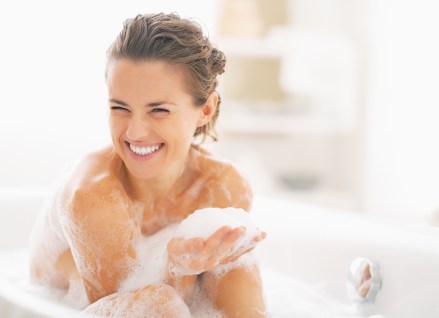 Portrait of happy young woman playing with foam in bathtub; Shutterstock ID 169271357; Comments: Art USe