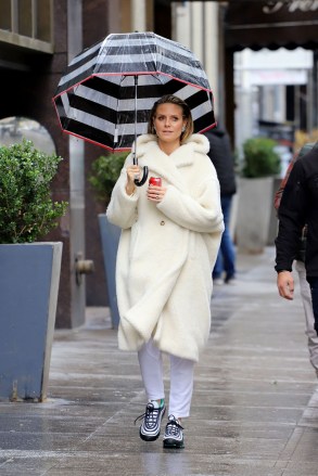 A bundled up Heidi Klum braves the rain with an umbrella and a can of Coke in Los Angeles, California. The newly engaged supermodel was spotted on the set on Germany's Next Topmodel with her sparkler from fianc√© Tom Kaulitz on full display. Wrapped up in an on-trend cream teddy coat, and butterfly earrings, Heidi strolled through Donwtown Los Angeles with a striking striped umbrella and a can of Coca Cola. She had her hair slicked back showing off her beautifully made up face as she made her way to filming the reality show.Coat ‚Äì Max MaraPictured: Heidi KlumRef: SPL5064037 130219 NON-EXCLUSIVEPicture by: SplashNews.comSplash News and PicturesLos Angeles: 310-821-2666New York: 212-619-2666London: +44 (0)20 7644 7656Berlin: +49 175 3764 166photodesk@splashnews.comWorld Rights