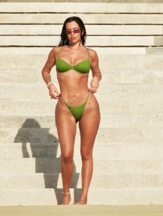 EXCLUSIVE: Kylie Jenner's BFF Anastasia 'Stassie' Karanikolaou looks amazing in a lime green bikini as she hits the beach over the Thanksgiving holiday.  The model and social media influencer, 25, showed off her slender figure as she and a friend walked along the sand near the luxurious Nobu Hotel in Cabo San Lucas, Mexico.  November 24, 2022 Pictured: Anastasia 'Stassie' Karanikolaou.  Photo credit: MEGA TheMegaAgency.com +1 888 505 6342 (Mega Agency TagID: MEGA920866_001.jpg) [Photo via Mega Agency]