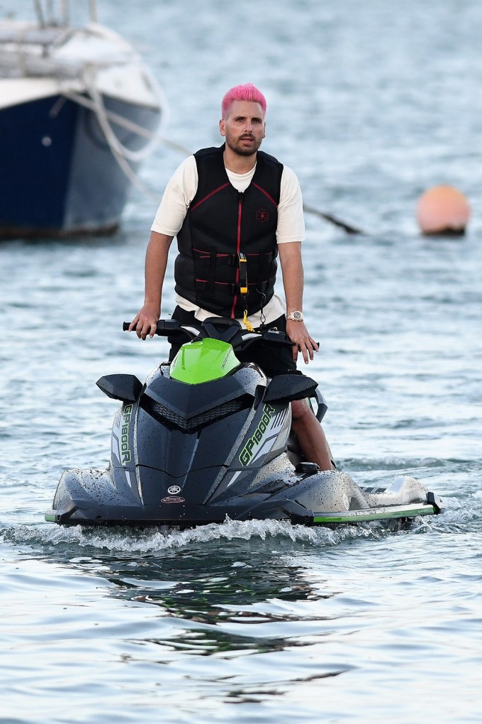 EXCLUSIVE: Scott Disick shows off his new pink hair as he takes a ride on a jet ski while girlfriend Amelia Hamlin waits on the dock with a friend in Miami