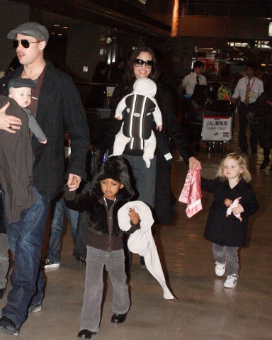 Brad Pitt with Knox Leon Jolie-Pitt and Zahara Jolie-Pitt, Angelina Jolie with Viviene Marcheline Jolie-Pitt, Shiloh Jolie-Pitt and Maddox Chivan Thornton Jolie-Pitt
Brad Pitt and Angelina Jolie with family arriving at Narita International airport, Chiba, Japan - 27 Jan 2009
Brad Pitt and Angelina Jolie showed off their twins for the first time in public today after touching down at Narita International airport in Japan. When the twins, Vivienne Marcheline and Knox Leon, were born six months ago the couple sold the first pictures of the newborns to American magazine People and British magazine Hello! for $14million - with the money going to charity. Since then the Hollywood pair have kept the latest additions to their family under wraps. However, the whole brood was on show today as they walked hand in hand through the airport. Little Vivienne - named after Angelina's late mother - proved to be the spitting image of older sister Shiloh, while her twin brother Knox was dressed just like his dad in a grey jumper and flat cap. With their hands full with the twins, Brad and Angelina's older children Pax, Maddox, Shiloh and Zahara dutifully walked beside their parents. The family are in Japan to promote Pitt's new film 'The Curious Case of Benjamin Button'.