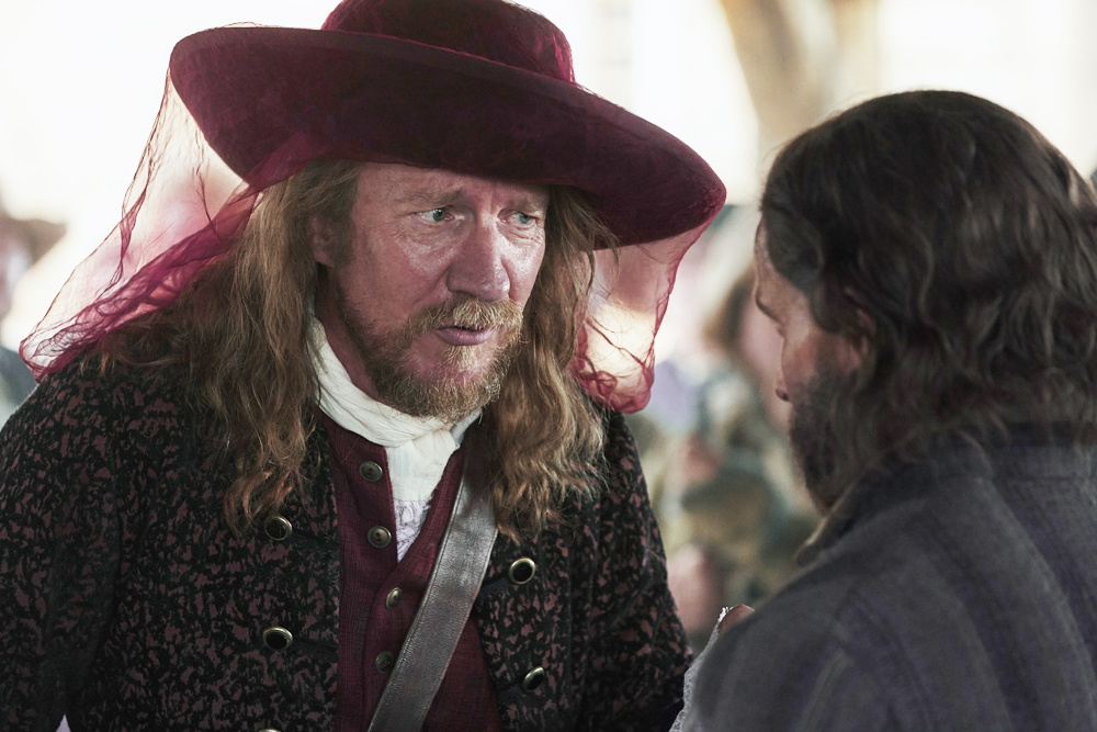 Trepagny (David Thewlis) speaks to Rene Sel (Christian Cooke) in the Trade Hall in Wobik. (National Geographic/Peter H. Stranks)