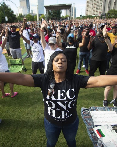 Woman prays during a OneRace March on Atlanta prayer service and march in response to recent racially violence, in Atlanta Juneteenth , Atlanta, United States - 19 Jun 2020