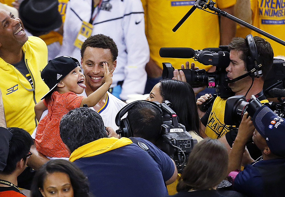 Golden State Warriors guard Stephen Curry holds his daughter Riley after Game 5 of the NBA basketball Western Conference finals against the Houston Rockets in Oakland, Calif., Wednesday, May 27, 2015. The Warriors won 104-90 and advanced to the NBA Finals. (AP Photo/Tony Avelar)