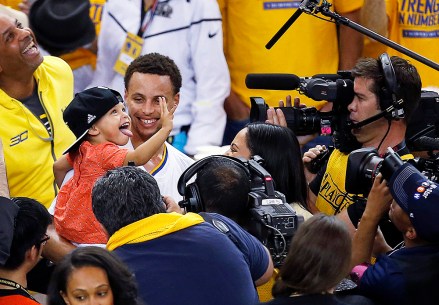 Golden State Warriors guard Stephen Curry holds his daughter Riley after Game 5 of the NBA basketball Western Conference finals against the Houston Rockets in Oakland, Calif., Wednesday, May 27, 2015. The Warriors won 104-90 and advanced to the NBA Finals. (AP Photo/Tony Avelar)