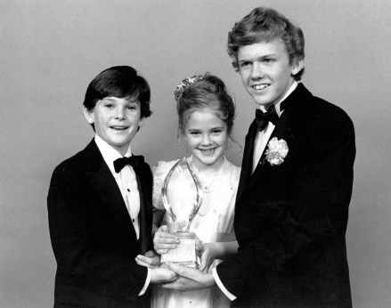 Drew Barrymore, center, Henry Thomas, left, and Robert Macnaughton, the young stars of Steven Spielberg's film "ET, the extraterrestrial," pose with their People's Choice Award after the film was named Favorite Movie at the 9th Annual People's Choice Awards in Santa Monica, California, on March 17, 1983. (AP Photo/Lennox McLendon)