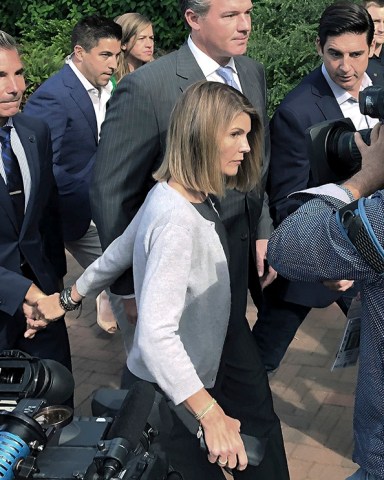 Lori Loughlin depart federal court with her husband, clothing designer Mossimo Giannulli, left, on Tuesday, Aug. 27, 2019, in Boston, after a hearing in a nationwide college admissions bribery scandal. (AP Photo/Philip Marcelo)