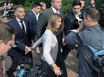 Lori Loughlin departs federal court with her husband, clothing designer Mossimo Giannulli, left, on Tuesday, Aug.  27, 2019, in Boston, after a hearing in a nationwide college admissions bribery scandal.  (AP Photo/Philip Marcelo)