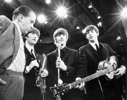 Amerikalı TV sunucusu Ed Sullivan, solda, İngiliz pop grubu The Beatles'ın üç üyesiyle, 8 Şubat 1964'te New York'taki TV şovunun provası sırasında konuşuyor. Soldan, Sullivan, John Lennon, Ringo Starr ve Paul McCartney.  Grubun dördüncü üyesi George Harrison, hastalığı nedeniyle provayı kaçırdı.  (AP Fotoğrafı)