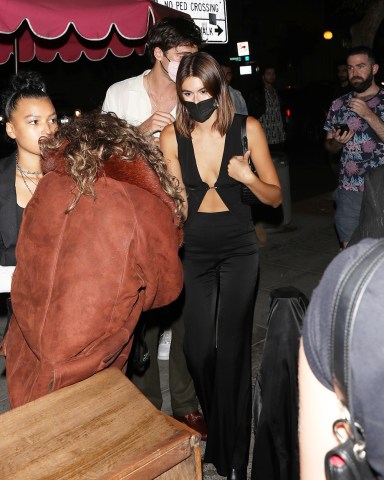 Kaia Gerber and Jacob Elordi are camera shy as the couple go club hopping in West Hollywood. First, they partied at the Nice Guy with friends and then finished the night at the Delilah restaurant. 17 Jun 2021 Pictured: Kaia Gerber and Jacob Elordi. Photo credit: Photographer Group/MEGA TheMegaAgency.com +1 888 505 6342 (Mega Agency TagID: MEGA763210_004.jpg) [Photo via Mega Agency]