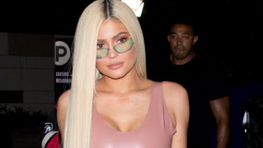 Kylie Jenner hides her face as she steps out for lunch in bright