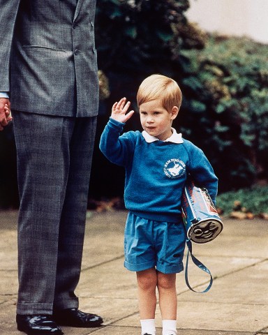 FILE - In this Sept. 16, 1987 file photo, Britain's Prince Harry waves to photographers whilst holding a 'Thomas The Tank Engine' bag on his first day at a kindergarten in Notting Hill, West London. Britain's Prince Harry has recorded a special message to celebrate the 75th anniversary of Thomas The Tank Engine, introducing a new program called 'Thomas And Friends: The Royal Engine' that includes the Queen Elizabeth II and his father Prince Charles as animated characters which will be screened in the US on Netflix on 1 May, 2020 and in the UK on Channel 5 Milkshake at 9:05am on 2 May, 2020.  (AP Photo/Martin Cleaver, File)