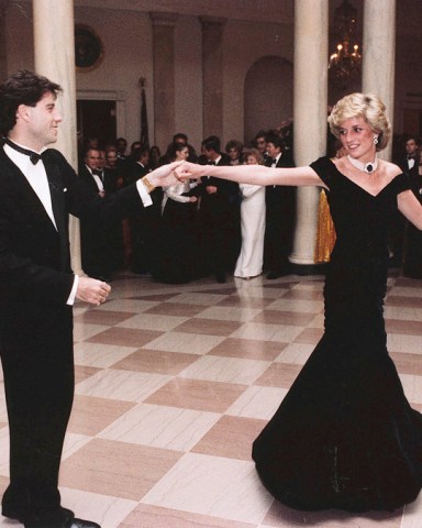 FILE - In this Nov. 9, 1985 photo provided by the Ronald Reagan Library, actor John Travolta dances with Princess Diana at a White House dinner in Washington. This outfit is featured in an exhibition of 25 dresses and outfits worn by Diana entitled "Diana: Her Fashion Story" at Kensington Palace in London, opening on Friday, Feb. 24, 2017. (Ronald Reagan Library via AP, File)