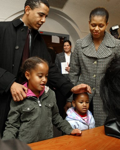 Illinois Democratic U.S. Senate candidate Barack Obama checks with his wife Michelle, daughters Malis, left, and Sasha in with poll workers, as he gets in line to cast his vote at Catholic Theological union polling place Tuesday, Nov. 2, 2004, in Chicago.(AP Photo/Nam Y. Huh)