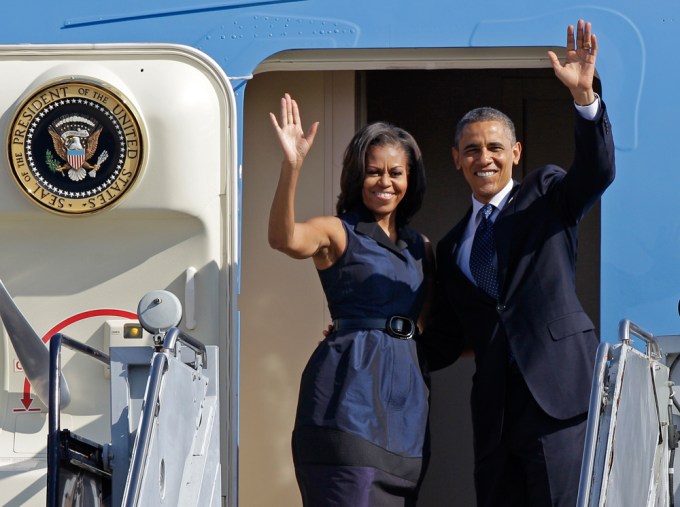 Barack and Michelle Obama wave as they board Air Force One