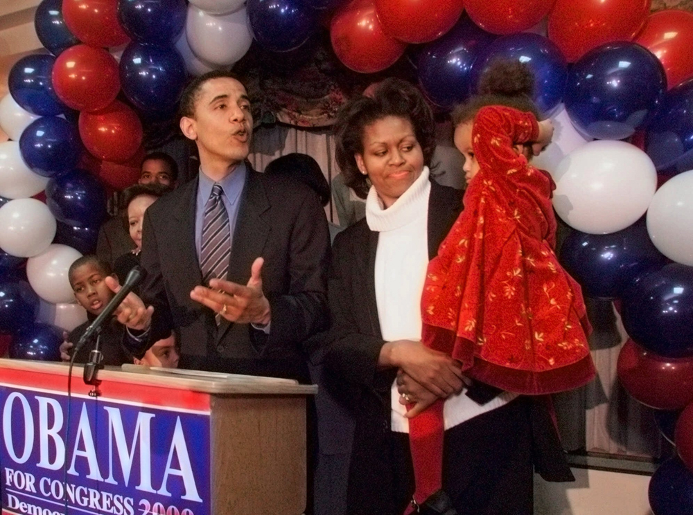 Barack Obama, District One Democratic candidate for Congress, delivers his concession speech to supporters while his wife Michelle tends to their daughter Malia during a post-primary function Tuesday, March 21, 2000, in Chicago. Incumbent Congressman Bobby Rush won the Democratic nomination. (AP Photo/Frank Polich)