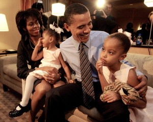 Illinois State Senator Barack Obama, D-Chicago, talks with his daughter Malia, 5, as his wife Michelle holds their other daughter Sasha, 2, in their hotel suite on the evening of the US Senate Democratic primary Tuesday, March 16, 2004 in Chicago. Obama is in a seven-way race in the Democratic state wide primary. (AP Photo/M. Spencer Green)