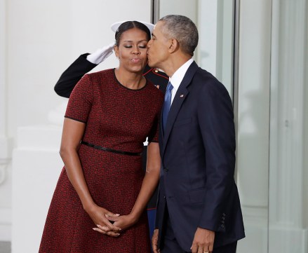El presidente Barack Obama besa a la primera dama Michelle Obama mientras esperan la llegada del presidente electo Donald Trump y su esposa Melania, el viernes 20 de enero de 2017, a la Casa Blanca en Washington.  (Foto AP/Evan Vucci)