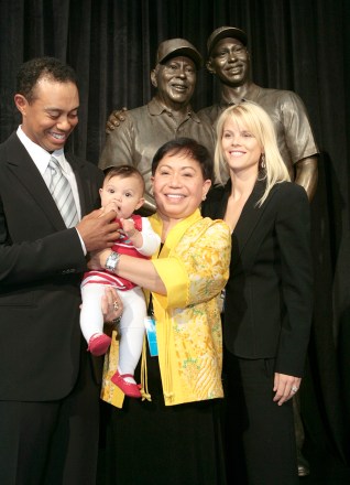 Tiger Woods, left, smiles as he stands with his daughter Sam, left to right, mother Kultida, and wife Elin Nordegren, next to a bronze statue bearing the likeness of Tiger with his late father Earl Woods, during its unveiling inside the the Tiger Woods Learning Center in Anaheim, Calif., Monday, Jan. 21, 2008. (AP Photo/Damian Dovarganes)