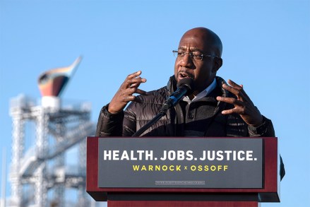 Democratic Georgia Senate challenger the Rev. Raphael Warnock addresses supporters during a rally with Jon Ossoff in Atlanta on the first day of early voting for the senate runoff Monday, Dec. 14, 2020. (AP Photo/Ben Gray)