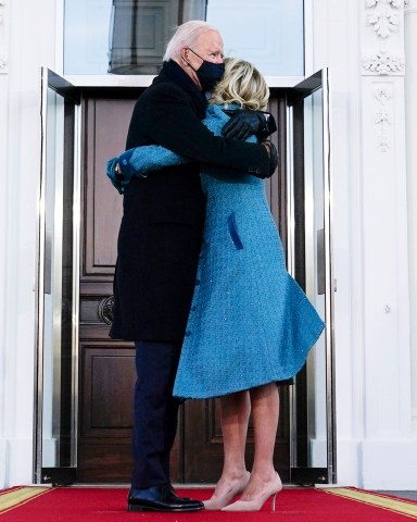 President Joe Biden hugs first lady Jill Biden as they arrive at the North Portico of the White House, Wednesday, Jan. 20, 2021, in Washington. (AP Photo/Evan Vucci)