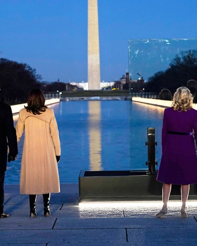 With the Washington Monument in the background, President-elect Joe Biden stands with his wife Jill Biden and Vice President-elect Kamala Harris stands with her husband Doug Emhoff as they look at lights placed around the Lincoln Memorial Reflecting Pool during a COVID-19 memorial Tuesday, Jan. 19, 2021, in Washington. (AP Photo/Evan Vucci)