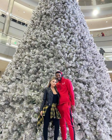 EXCLUSIVE: New couple Larsa Pippen and Malik Beasley get in the festive spirit as they pose in front of a giant Christmas tree in his hometown of Minnesota. The Real Housewives of Miami star, 46, and the Minnesota Timberwolves point guard, 24, posed for the camera on Sunday, December 20. 20 Dec 2020 Pictured: Larsa Pippen and Malik Beasley. Photo credit: MEGA TheMegaAgency.com +1 888 505 6342 (Mega Agency TagID: MEGA722344_001.jpg) [Photo via Mega Agency]