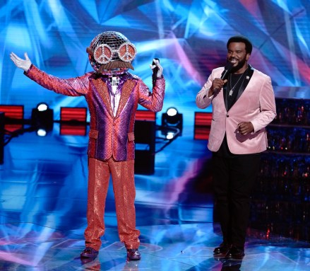 THE MASKED DANCER: L-R: Disco Ball and host Craig Robinson. THE MASKED DANCER will have a special premiere Sunday, Dec. 27 (8:00-9:00 PM ET/5:00-6:00 PM PT, Live to all Time Zones), before having its time period premiere Wednesday, Jan. 6 (8:00-9:00 PM ET/PT) on FOX. CR: Michael Becker/FOX.© 2021 FOX Media LLC.