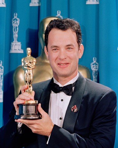Tom Hanks holds his first Oscar backstage at the 66th Academy Awards ceremony held at the Dorothy Chandler Pavilion in Los Angeles, March 21, 1994. Tom Hanks won the Best Actor Oscar for his role as Andrew Beckett in the movie Philadelphia. (AP Photo/NewsBase)