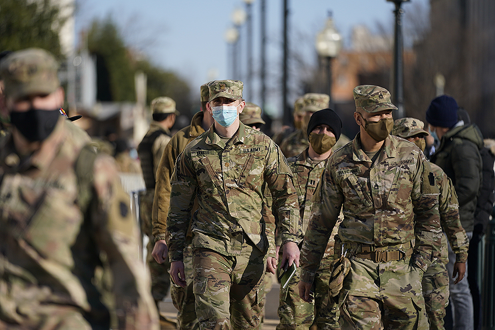 DC National Guard walk around the Capitol grounds, Thursday morning, Jan. 7, 2021 in Washington. The House and Senate certified the Democrat's electoral college win early Thursday after a violent throng of pro-Trump rioters spent hours Wednesday running rampant through the Capitol. A woman was fatally shot, windows were bashed and the mob forced shaken lawmakers and aides to flee the building, shielded by Capitol Police. (AP Photo/Julio Cortez)