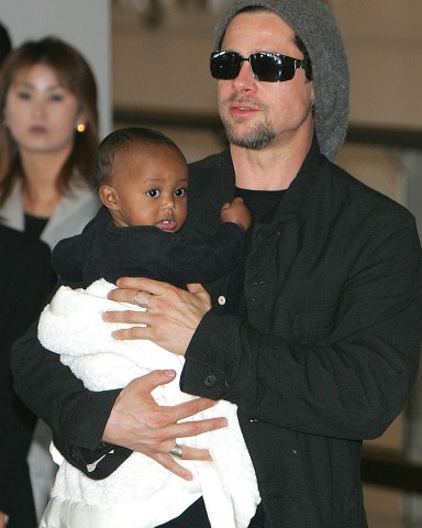 Hollywood actor Brad Pitt holds Angelina Jolie's daughter Zahara upon his arrival at Tokyo's international airport at Narita on Sunday Nov. 27, 2005. The actor, along with actress and UNHCR Goodwill Ambassador Angelina Jolie, arrived for the Japan showing of their new movie, Mr. and Mrs. Smith, scheduled for December 3. Before flying into Japan, Brad Pitt, visiting Pakistan with Angelina Jolie, donated  40 orthopaedic beds to an Islamabad hospital has been struggling to cope with thousands of serious medical cases since the devastating Oct. 8 earthquake in northern Pakistan, according to the UN agency.(AP Photo/Shizuo Kambayashi)