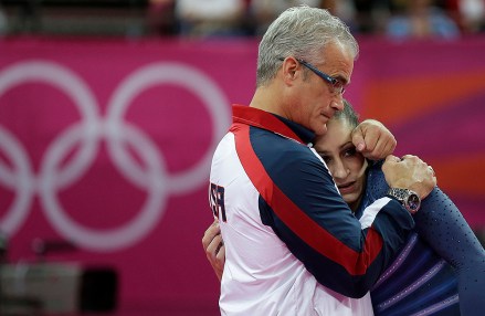 FILE - In this Aug. 7, 2012, file photo, U.S. gymnast Jordyn Wieber is consoled by head coach John Geddert after her performance during the artistic gymnastics women's floor exercise final at the 2012 Summer Olympics in London. The finality of the end of her gymnastics career hit Wieber suddenly. Too far removed from the high-intensity training needed to continue at the elite level and ineligible to compete collegiately because she turned professional as a high schooler, the 2011 world champion and 2012 Olympic gold medalist needed a place to vent. (AP Photo/Gregory Bull, File)