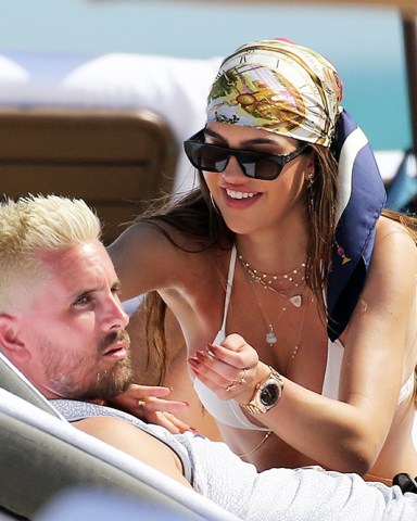 Bikini clad Amelia Hamlin happily applies sunscreen to boyfriend Scott Disick as they relax on the beach on Valentine's Day in Miami. 14 Feb 2021 Pictured: Scott Disick; Amelia Hamlin. Photo credit: MEGA TheMegaAgency.com +1 888 505 6342 (Mega Agency TagID: MEGA733444_007.jpg) [Photo via Mega Agency]