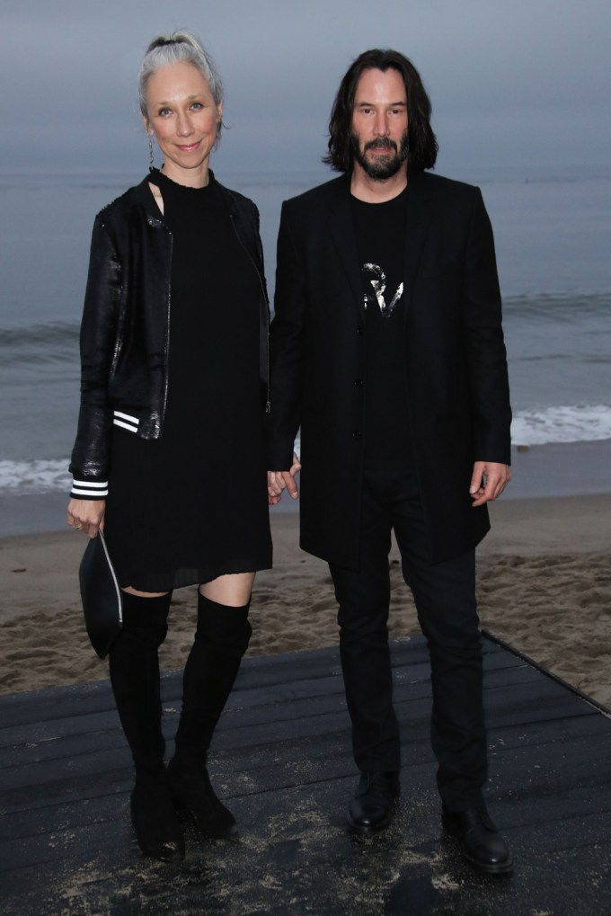 Keanu Reeves and Alexandra Grant hold hands