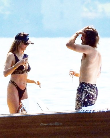 Torno, ITALY - *EXCLUSIVE* - German Model Heidi Klum and her husband, Tokio Hotel's Tom Kaulitz pack on the PDA during their motorboat ride out in Torno, Lake Como.They enjoyed a few drinks on the boat and set the temperatures soaring even further with a loved-up display as they kissed passionately out in the Italian sunshine as Tom when shirtless and took control of the wheel! The former Victoria's Secret Angel Heidi donned her sexy Versace two-piece bikini set.The couple was seen checking out a few properties for sale in the prestigious affluent area where the likes of A-list Hollywood superstars such as George Clooney are residing. Perhaps it's an exciting attractive move for Heidi and Tom as they look to purchase a home in Northern Italy’s Lombardy region known for its stunning dramatic scenery.Pictured: Heidi Klum - Tom KaulitzBACKGRID USA 29 JUNE 2023 BYLINE MUST READ: Cobra Team / BACKGRIDUSA: +1 310 798 9111 / usasales@backgrid.comUK: +44 208 344 2007 / uksales@backgrid.com*UK Clients - Pictures Containing ChildrenPlease Pixelate Face Prior To Publication*
