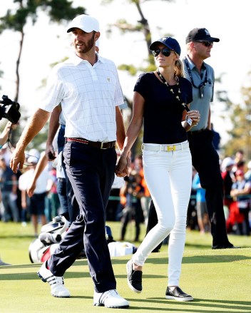United States' Dustin Johnson holds hands with his partner Paulina Gretzky as they leave the course following his foursome win with teammate Jordan Spieth over International team player's Danny Lee of New Zealand Marc Leishman of Australia at the Presidents Cup golf tournament at the Jack Nicklaus Golf Club Korea, in Incheon, South Korea
South Korea Presidents Cup Golf, Incheon, South Korea