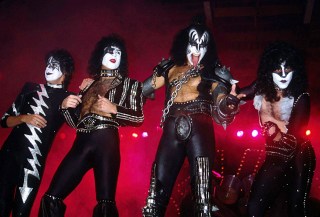 A Color Photo of Members of Kiss Posing On Stage Gene Simmons Pointing at the Camera and Sticking His Tongue out in 1982
Kiss 1982