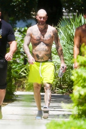 Miami, Florida - * EXCLUSIVE * - Adam Levine, his personal trainer Austin Pollen and his bodyguard walk to the gym in Miami.  The Maroon 5 singer was left without a shirt to beat the heat in Florida, wearing a pair of neon shorts and showing off some of his Calvins!  Pictured: Adam Levine BACKGRID USA JULY 1, 2021 BYLINE MUST READ: SBCH / BACKGRID USA: +1 310 798 9111 / usasales@backgrid.com UK: +44 208 344 2007 / uksales@backgrid.com - * Photos Please for children Console.com Pixelation of the face before publication *