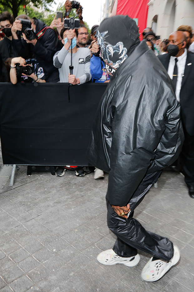 kanye west using a full face covering black mask, a