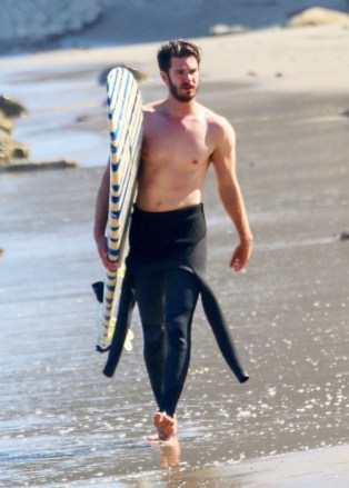 Malibu, CA - *EXCLUSIVE* - Revealing his fit form, Andrew Garfield took off his wetsuit midway as he was seen surfing in LA as reports suggest the actor signs a multi-movie MCU deal.  Actor made fun of retiring in April to clarify later "'I'm working hard and I'm loving the work I'm doing, but at the same time, I need a month or two off.  A month's break, maybe two