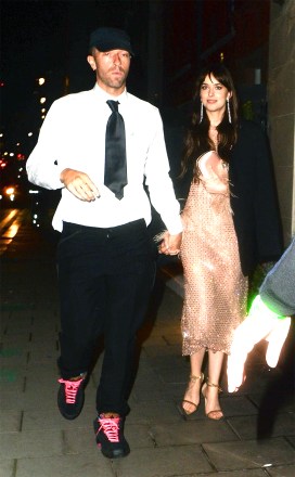 London, UNITED KINGDOM - * EXCLUSIVE * Cold play star Chris Martin and longtime girlfriend Dakota Johnson spotted at the Claridges Hotel in London on Wednesday night.  The star can be seen wearing a shirt and tie along with a pair of chunky trainers and standout neon pink laces.  Pictured: Chris Martin, Dakota Johnson BACKGRID USA 14 OCTOBER 2021 BYLINE MUST READ: TJ / BACKGRID USA: +1 310 798 9111 / usasales@backgrid.com UK: +44 208 344 2007 / uksales@backgrid.com * UK Clients - Pictures Containing Children Please Pixelate Face Prior To Publication *