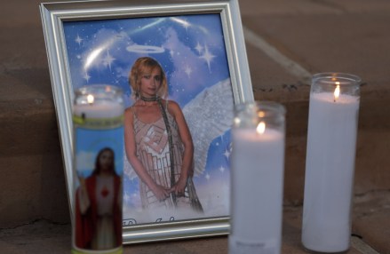 Candles are placed next to a photograph of cinematographer Halyna Hutchins during a vigil in her honor in Albuquerque, NM.  Hutchins was fatally shot on Thursday, Oct.  21, after an assistant director unwittingly handed actor Alec Baldwin a loaded weapon and told him it was safe to use on the set of a Western filmed in Santa Fe, NM Prop Firearm Movie Set, Albuquerque, United States - 23 Oct 2021