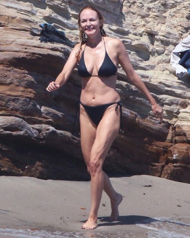Los Angeles, CA  - *EXCLUSIVE*  - Heather Graham, 52 slips into a bikini with a mystery man on the beach in Los Angeles. Wearing a black bikini, Heather took on a few strong waves as she frolicked on the sunny beach. Heather appeared to be enjoying her time with her mystery man as she couldn't hold back a gleeful smile.Pictured: Heather GrahamBACKGRID USA 4 SEPTEMBER 2022 BYLINE MUST READ: LENS / BACKGRIDUSA: +1 310 798 9111 / usasales@backgrid.comUK: +44 208 344 2007 / uksales@backgrid.com*UK Clients - Pictures Containing ChildrenPlease Pixelate Face Prior To Publication*