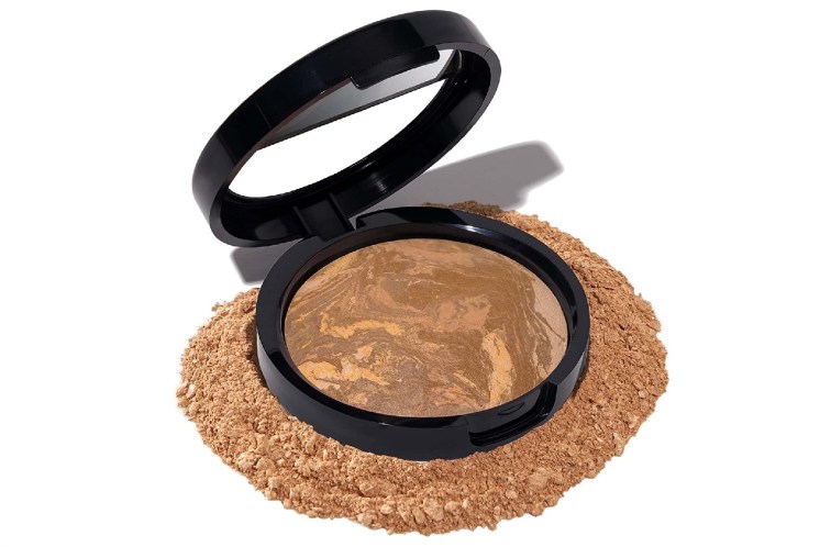 laura geller powder foundation with powder surrounding the product