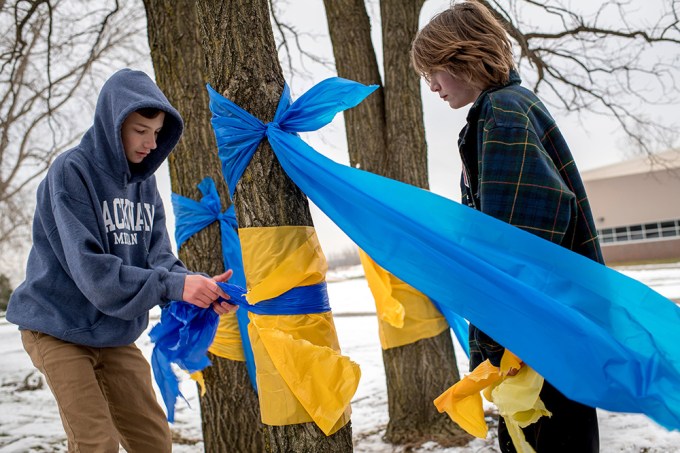 Students tie ribbons around trees